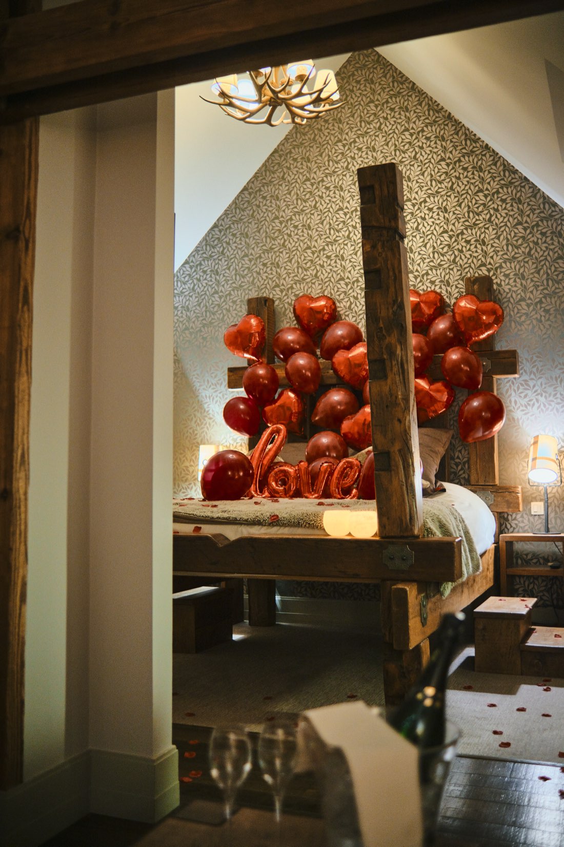 Gîte — lit à baldaquin en bois décoré avec ballons et pétales Boxe Deco