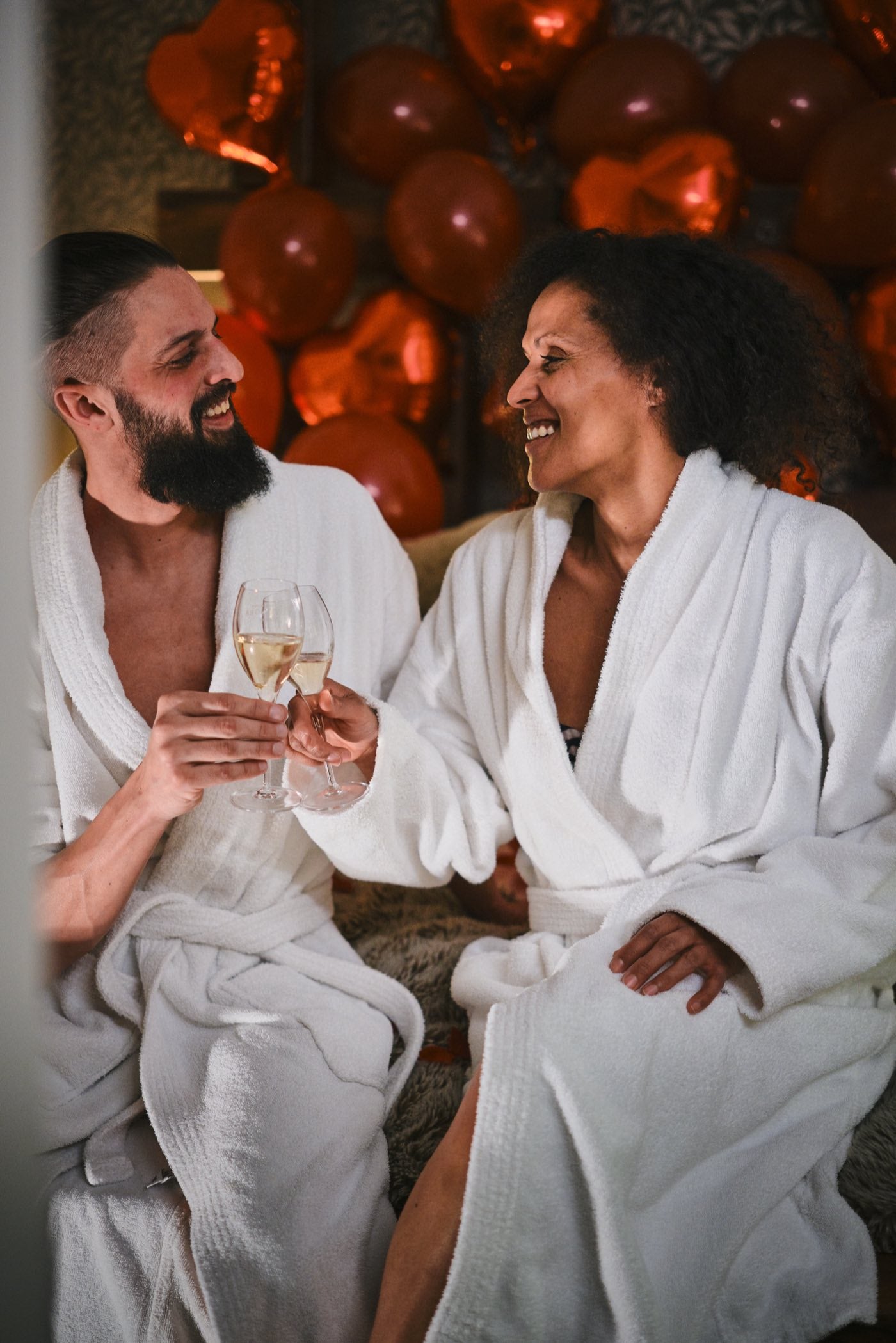 Couple en peignoirs avec champagne dans une chambre d'hôtel décorée avec Boxe Deco